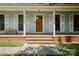 Close-up of the front entrance with a wooden door, white columns, and brick steps leading to the porch at 2635 Clover Hill Ln, Charlotte, NC 28215