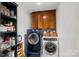 Convenient laundry room with modern washer and dryer units, plus storage cabinets and shelving at 2635 Clover Hill Ln, Charlotte, NC 28215