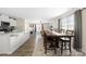Open-concept dining area with a large wooden table, wood floors, and view into the living room and kitchen at 2754 Legacy Ridge Ln, Catawba, NC 28609