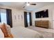 Bedroom featuring a large window, ceiling fan, carpeted floors, TV, and a wooden dresser at 3424 Saint Clair Nw Ct, Concord, NC 28027