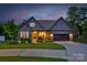 Charming home with a well-manicured lawn, a two-car garage, and inviting front porch at twilight at 3424 Saint Clair Nw Ct, Concord, NC 28027