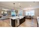 Open concept kitchen with island, farm sink, and stainless steel appliances, seamlessly flowing into living spaces at 3424 Saint Clair Nw Ct, Concord, NC 28027