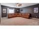 Recreation room with dark grey walls, carpeted floors, ceiling fan and a large leather sectional at 3424 Saint Clair Nw Ct, Concord, NC 28027