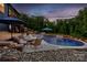 Inviting pool with spa, travertine tile, manicured landscaping, and relaxing lounge chairs at dusk at 3424 Saint Clair Nw Ct, Concord, NC 28027