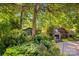 Beautiful backyard with stone fireplace, mature trees, and lush landscaping at 3755 River Rd, Richfield, NC 28137