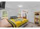 Bright bedroom with a yellow patterned quilt, natural light, and view into the ensuite bathroom at 3755 River Rd, Richfield, NC 28137