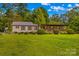 Charming single story home featuring covered porch, metal roof, manicured lawn, and mature trees at 3755 River Rd, Richfield, NC 28137