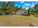 View of the garage, open carport, and mature landscaping on a sunny day at 3755 River Rd, Richfield, NC 28137