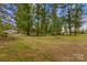 Expansive lot featuring mature trees and a glimpse of the house in the background at 3755 River Rd, Richfield, NC 28137