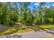 Gated property entrance on a quiet road with mature trees at 3755 River Rd, Richfield, NC 28137