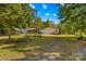 Picturesque property featuring a home, storage buildings, and verdant landscaping at 3755 River Rd, Richfield, NC 28137