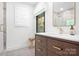 Modern bathroom featuring a wood vanity, stone floors, modern fixtures, and a stylish vanity mirror at 4316 Old Saybrook Ct, Charlotte, NC 28211