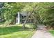 A charming home with green siding and a brick chimney surrounded by lush green trees at 4316 Old Saybrook Ct, Charlotte, NC 28211