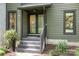 Close-up of a front entrance with a black framed glass door and brick stairs with decorative plants at 4316 Old Saybrook Ct, Charlotte, NC 28211