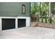 View of a two-car garage with black garage doors and brick foundation with a fenced backyard at 4316 Old Saybrook Ct, Charlotte, NC 28211