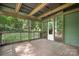 Inviting screened porch with wooden floors, exposed beams, and views of the lush greenery surrounding the home at 4316 Old Saybrook Ct, Charlotte, NC 28211