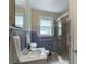 Bathroom with a ceramic tiled shower, window, neutral colored walls, and tiled floor at 439 Kershaw Country Club Rd, Kershaw, SC 29067