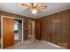 Bedroom featuring paneled walls, carpet floors, closet and access to other rooms at 439 Kershaw Country Club Rd, Kershaw, SC 29067