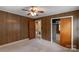 Bedroom featuring paneled walls, carpet floors, closet and access to another room at 439 Kershaw Country Club Rd, Kershaw, SC 29067