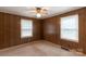 Bedroom features paneled walls, carpet flooring, and two windows providing natural light at 439 Kershaw Country Club Rd, Kershaw, SC 29067
