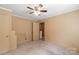 Bedroom featuring paneled walls, carpet flooring, a closet and access to another room at 439 Kershaw Country Club Rd, Kershaw, SC 29067
