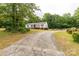 Ranch-style home with a long driveway surrounded by mature trees at 439 Kershaw Country Club Rd, Kershaw, SC 29067