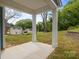Covered back patio with white columns and a concrete floor surrounded by lawn at 518 Herms Ave, Mount Holly, NC 28120