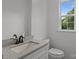 Bathroom with granite countertop and white cabinets next to window at 518 Herms Ave, Mount Holly, NC 28120