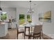 Eat-in dining area with glass table, modern chandelier, stainless steel appliances, and sliding glass door at 518 Herms Ave, Mount Holly, NC 28120