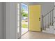 Welcoming entryway featuring a bright yellow front door and stairs at 518 Herms Ave, Mount Holly, NC 28120