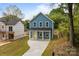 Charming two-story home with a yellow front door and a long concrete driveway at 518 Herms Ave, Mount Holly, NC 28120