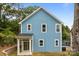Charming two-story home featuring light blue siding, white trim, and a welcoming front porch at 518 Herms Ave, Mount Holly, NC 28120