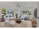 Bright living room with large windows, modern furniture, ceiling fan, and light wood floors at 518 Herms Ave, Mount Holly, NC 28120