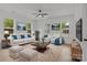 Bright living room with white furniture, hardwood floors, and natural light from large windows at 518 Herms Ave, Mount Holly, NC 28120