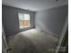 This cozy bedroom offers ample natural light from the window and neutral carpeting at 521 Donatello Ave, Charlotte, NC 28205