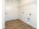 Bright laundry room with wood-look flooring and a wire shelf for storage at 5523 Pamplona Way, Charlotte, NC 28214
