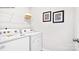 Well-equipped laundry room with white washer and dryer, shelving and decorative wall art at 5536 Pamplona Way, Charlotte, NC 28214