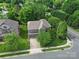 An aerial view shows a brick home with mature trees and landscaping in a residential neighborhood at 5633 Open Book Ln, Charlotte, NC 28270