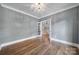 Open bedroom leading to stairs with hardwood floors, and a modern light fixture at 5633 Open Book Ln, Charlotte, NC 28270