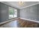 Well-lit bedroom with hardwood floors, crown molding, and a modern light fixture at 5633 Open Book Ln, Charlotte, NC 28270