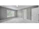 Neutral bedroom with carpet, white trim, large window, and two doors at 5633 Open Book Ln, Charlotte, NC 28270