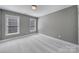 Spacious bedroom featuring neutral walls and carpet with natural light from two windows at 5633 Open Book Ln, Charlotte, NC 28270