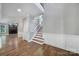 Inviting home foyer with hardwood floors, staircase, and decorative wainscoting at 5633 Open Book Ln, Charlotte, NC 28270