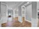 Inviting hallway with beautiful hardwood floors, white trim, and a view of the front door at 5633 Open Book Ln, Charlotte, NC 28270