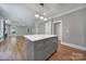 Spacious kitchen with gray island, hardwood floors, stainless appliances, and modern pendant lighting at 5633 Open Book Ln, Charlotte, NC 28270