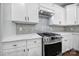 Close-up of a kitchen featuring stainless steel oven, white cabinets, countertops, and a gray tile backsplash at 5633 Open Book Ln, Charlotte, NC 28270