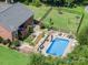 A serene aerial view of the backyard featuring a sparkling pool, manicured garden, and cozy lounge area at 600 Old Hardin Rd, Dallas, NC 28034