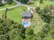 Overhead shot showcases the home with a vast lawn, pool, and recreation area, all surrounded by verdant trees at 600 Old Hardin Rd, Dallas, NC 28034