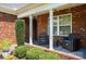 Inviting front porch with seating, decorative shrubbery and a brick facade at 600 Old Hardin Rd, Dallas, NC 28034