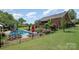 An inviting backyard with a sparkling pool, iron fencing, landscaping, and a brick house with a deck at 600 Old Hardin Rd, Dallas, NC 28034
